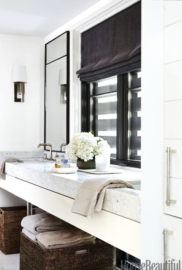 a white bathroom with a mirror and sink in the far end next to a window