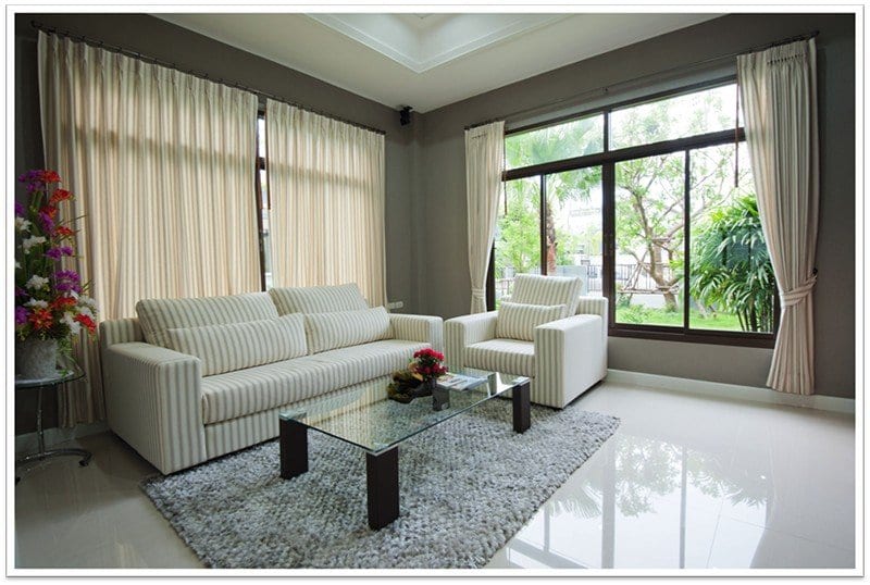 beautiful living room with a large window and a glass table in the center