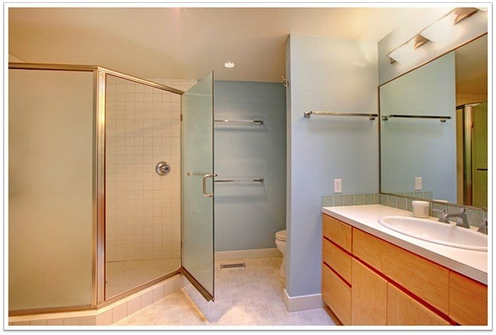 Glass shower door to the left with a countertop to the right