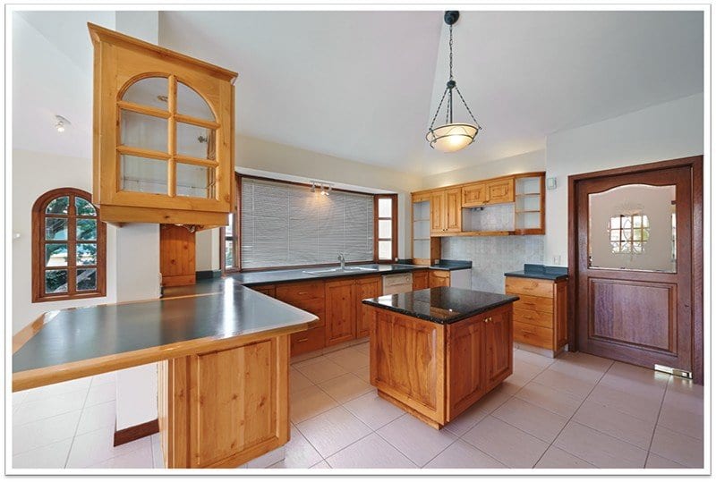 well spaced kitchen with wooden cabinets and an island in the center