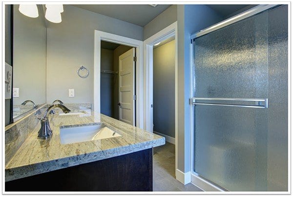 nice counter-top to the left with a sink and to the right a sliding glass shower