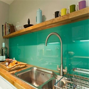 Green back painted glass as a backsplash in a kitchen