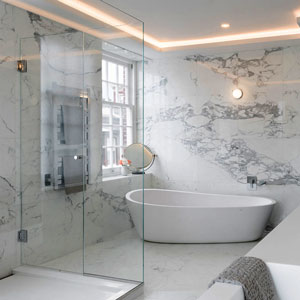 If you want your bathroom to be a luxurious retreat, a frameless clear glass shower with gold plated hardware and a fancy handle would be perfect