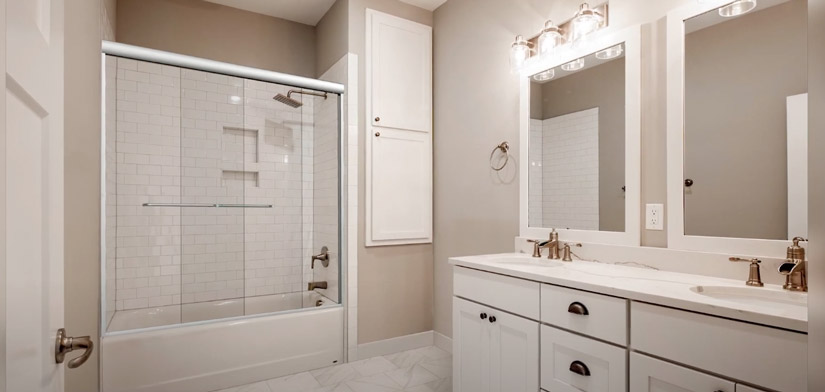 An ordinary bathtub with a shower head can be dressed up with sliding glass doors