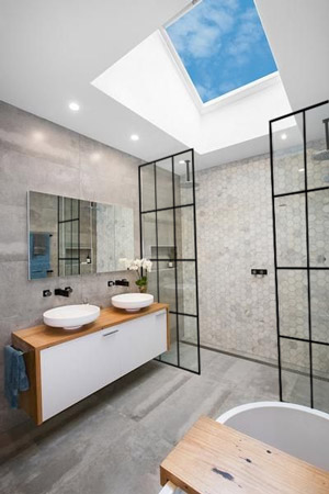 Glass exterior walls bring nature into a bathroom’s aesthetic without posing the practical concerns that would come with actually showering outside.