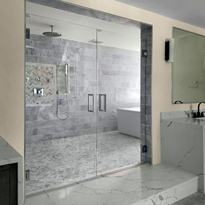 In-line door and panel: A swinging shower door is installed next to a fixed panel of glass on a tub or shower.