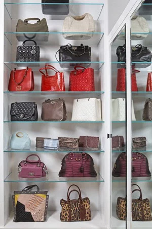 Purses displayed on glass shelving.