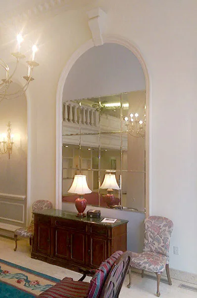 A mirrored wall can totally transform a living room, making it look larger and giving it a more cheery aspect.